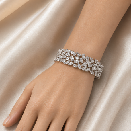 Silver bracelet on a hand against a satin background