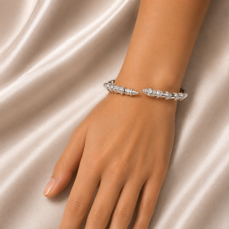 Silver bracelet on a hand against a satin background