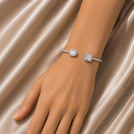 Silver bracelet with a diamond on a hand against a satin background