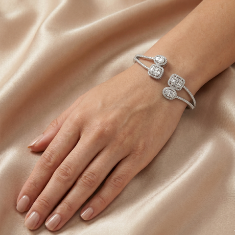 Silver bracelet with diamond accents on a hand against a satin background