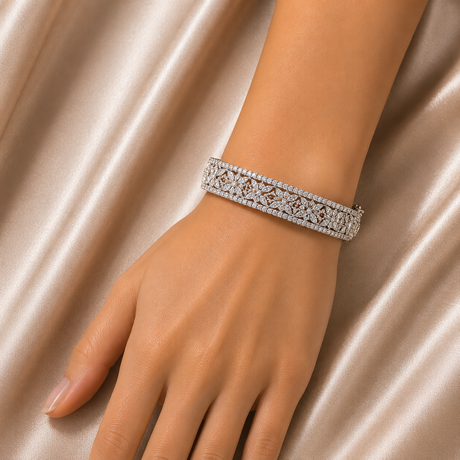 Silver bracelet with diamonds on a hand against a satin background
