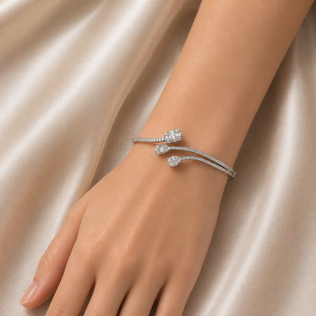 Silver bracelet with diamonds on a hand against a satin background