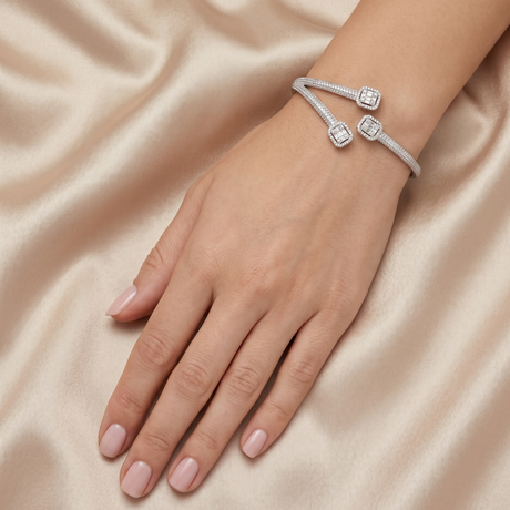 Silver bracelet with gemstones on a hand against a beige fabric background