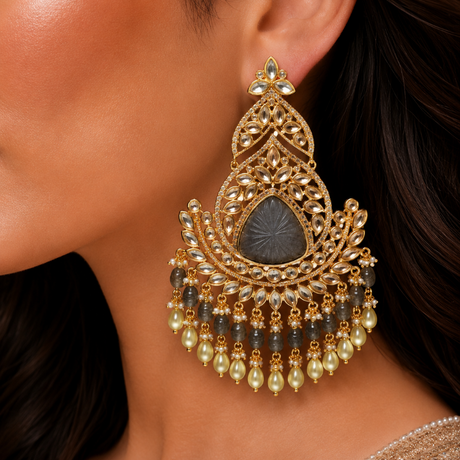 Close-up of a woman wearing an ornate gold earring with black and pearl accents.