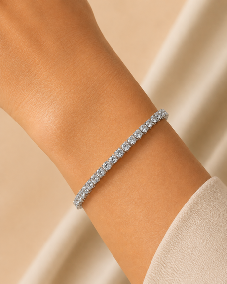 Silver bracelet on a person's wrist against a beige background