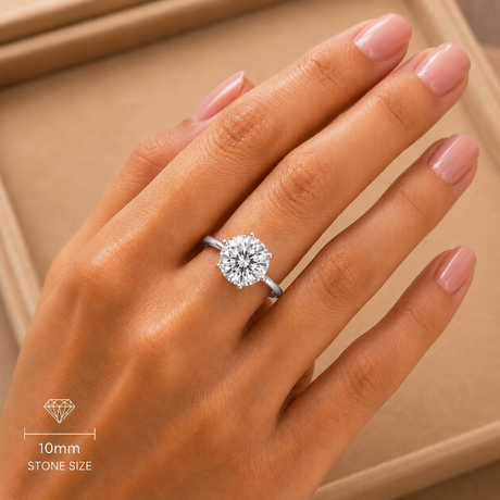 Diamond ring on a hand with a beige background