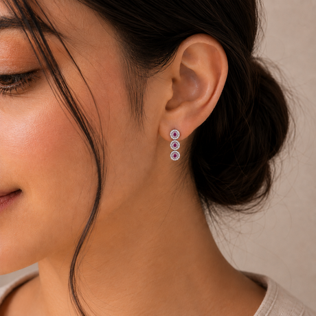 Close-up of a woman wearing colorful earrings with a neutral background