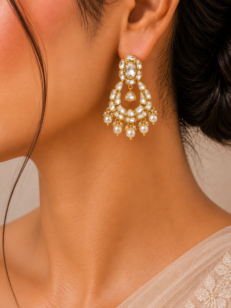 Close-up of a woman wearing a gold and pearl earring.