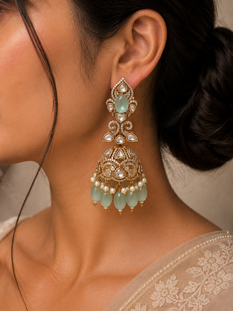 Close-up of a woman wearing a gold and green earring with a blurred background