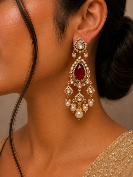 Close-up of a woman wearing a decorative earring with a red gemstone.