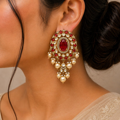 Close-up of a woman wearing an ornate earring with red gemstones and pearls.