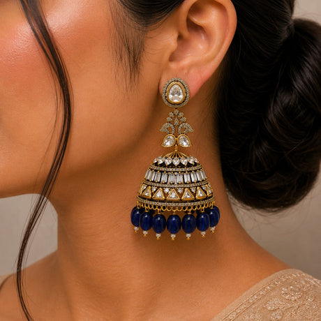 Close-up of a woman wearing a decorative earring with blue beads and gold accents.
