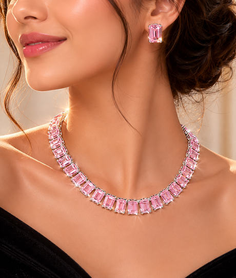 Woman wearing a pink gemstone necklace and earrings against a neutral background