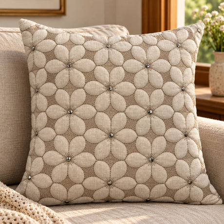 Beige floral embroidered cushion cover with raised flower design and silver button centres styled on a neutral sofa