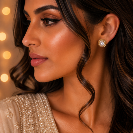 Close-up of a woman wearing gold earrings with a blurred warm background