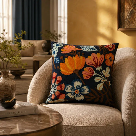 Navy embroidered floral cushion on a cream boucle armchair in a living room