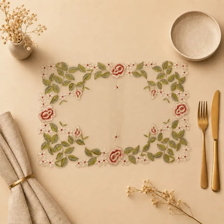 Decorative placemat with floral design on a beige surface with cutlery and napkins.