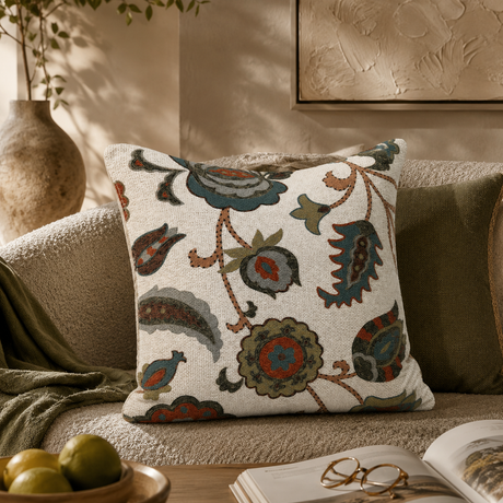 Decorative pillow with floral pattern on a couch in a cozy living room setting.